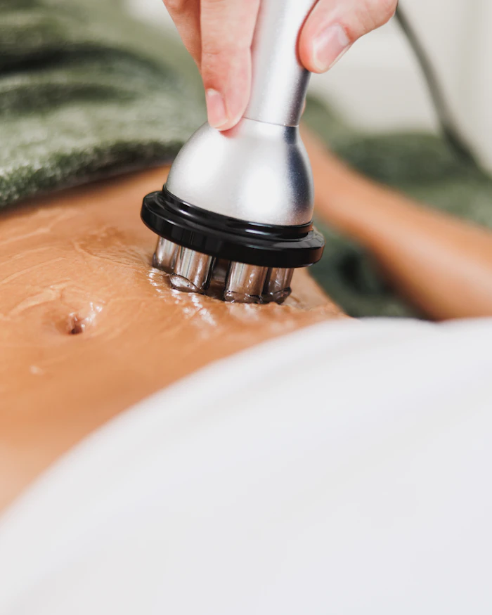 A body sculpting device being used on the abdomen